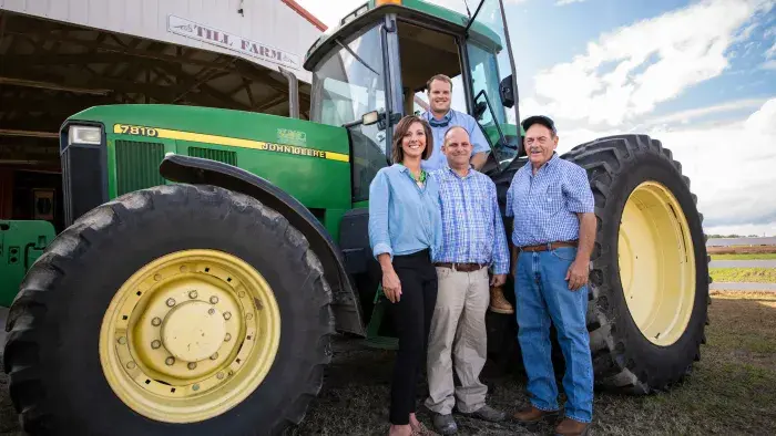 Family standing in front of their tractor