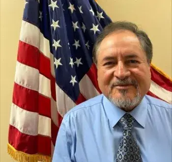 Photo of Arnoldo Hernandez in front of an American flag